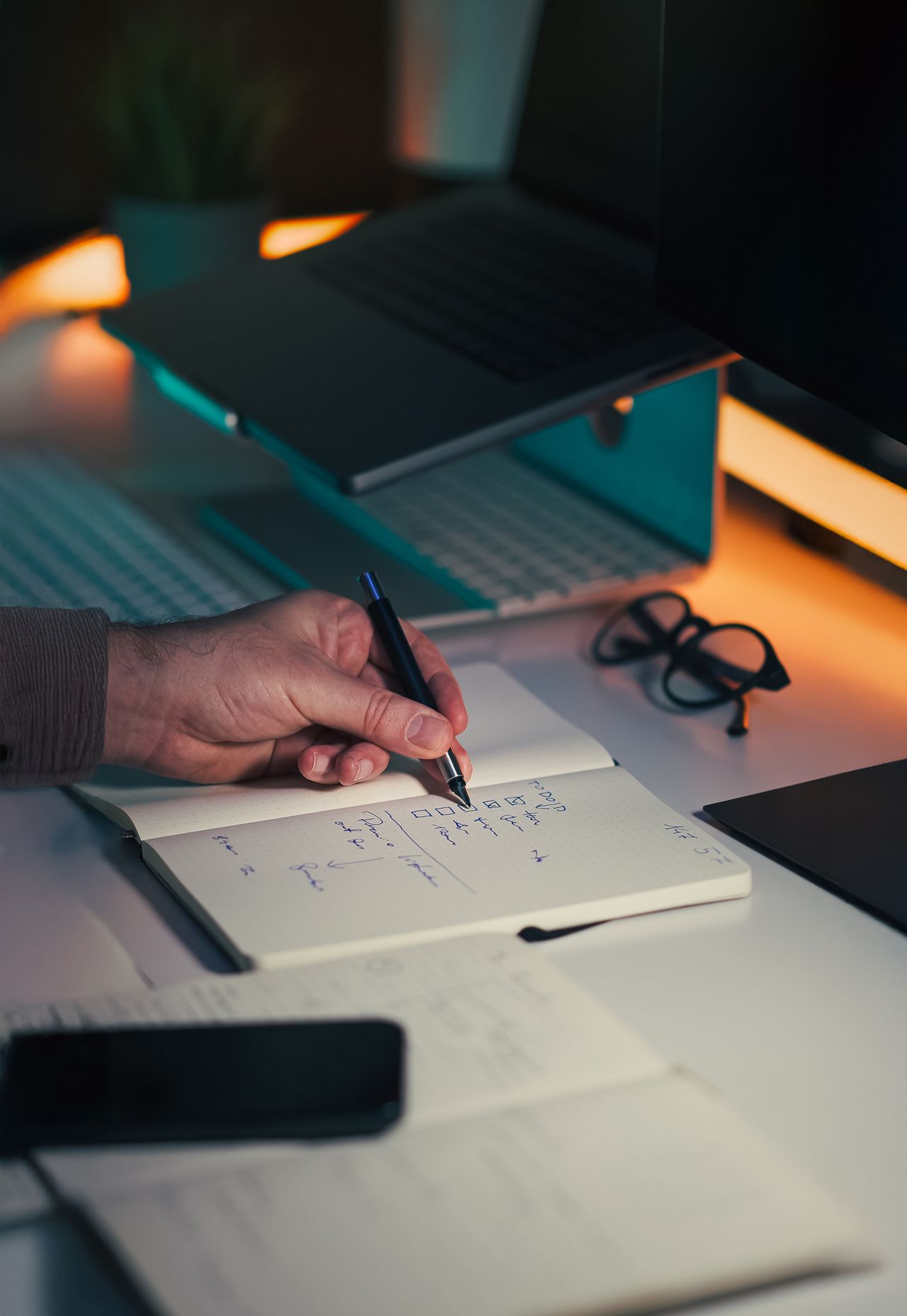 Desktop computer and someone writing on paper